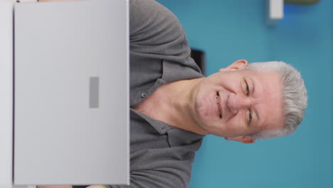 Vertical-video-of-Home-office-worker-man-smiles-at-camera.